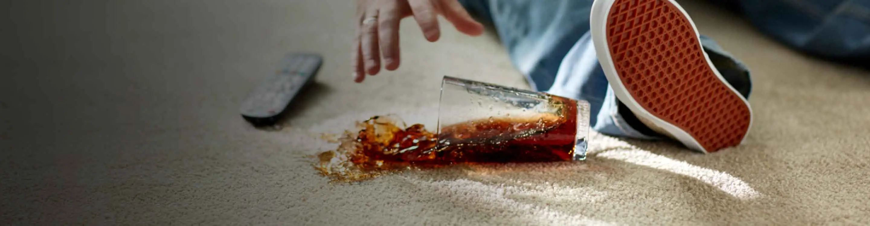 a child who has fallen on the carpet spilling a drink.