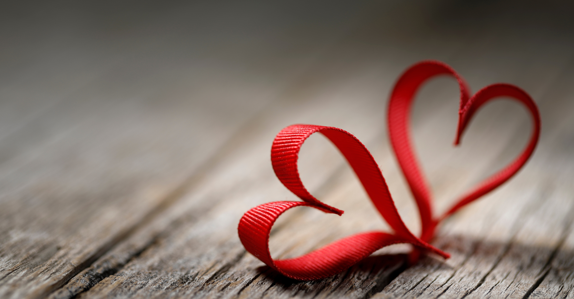 Woman sitting on a hardwood floor with a coffee mug in her hand.